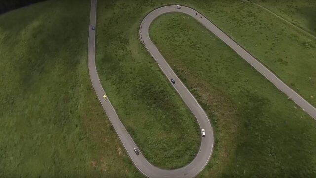 高原の曲がり道を進むサイクリングツアー