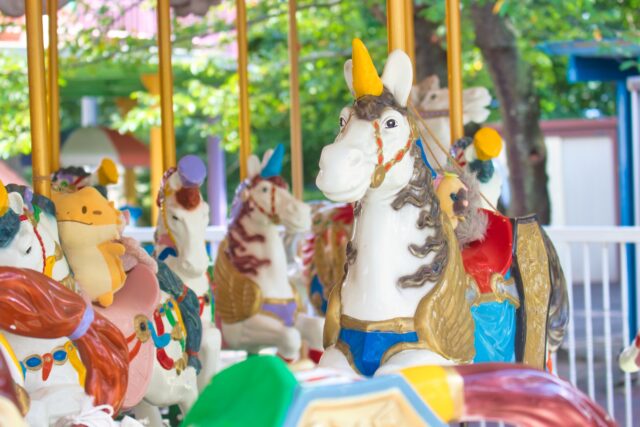 遊園地に並ぶカラフルなメリーゴーランドの馬