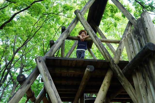 A child smiling on the wooden adventure course at Cortina Adventure Land