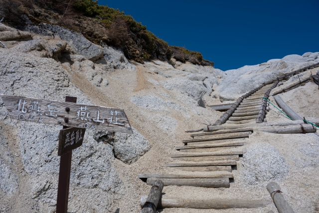 燕岳の山頂へ続く花崗岩の白い登山道と案内標識